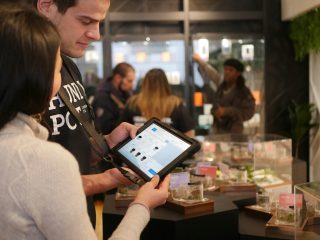 using tablet in shop Two coworkers using a tablet